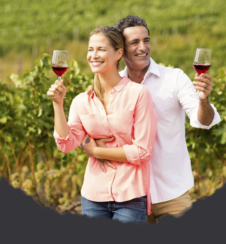 hombre y mujer con copa vino en viñedo